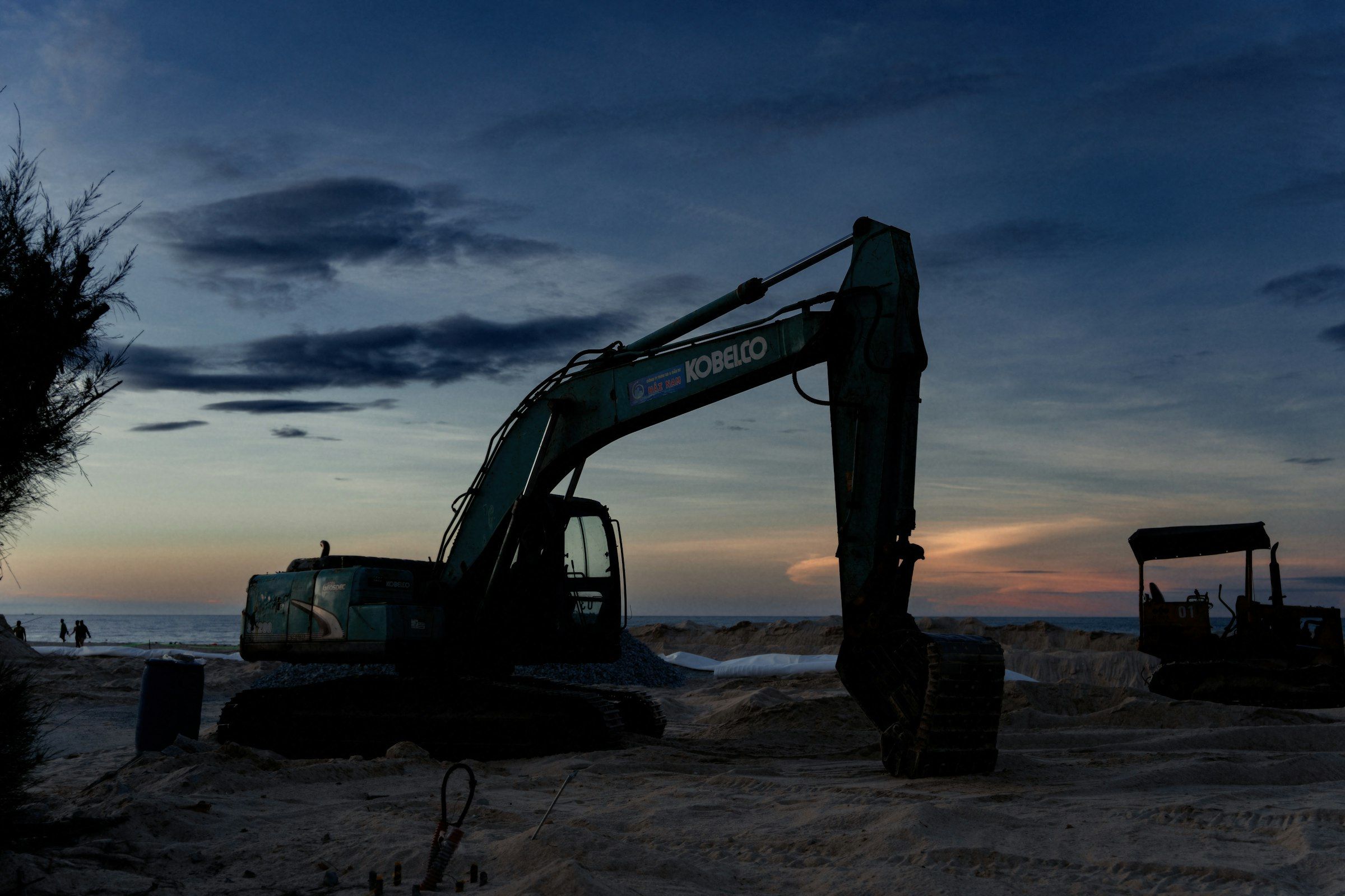 Excavator silhouetted on a jobsite at dusk